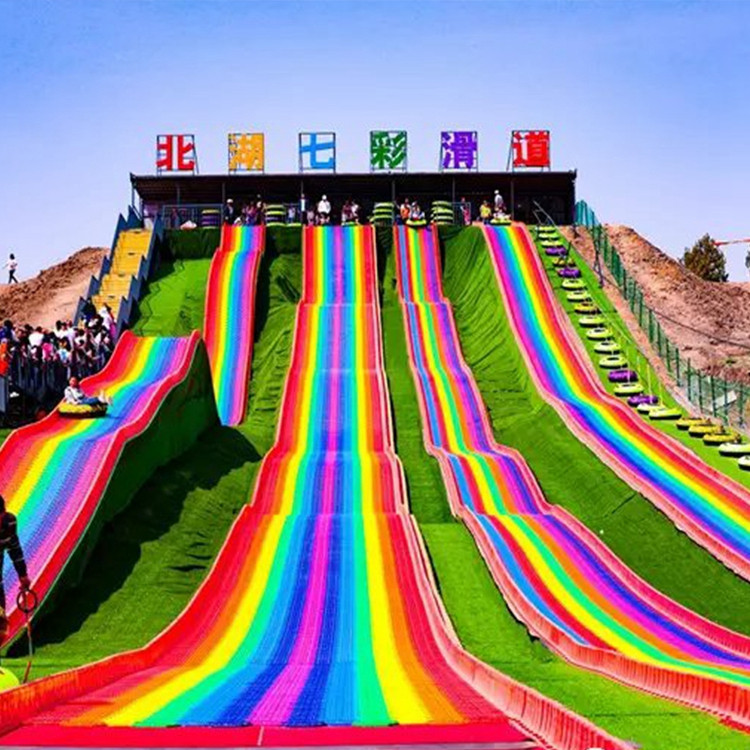 自然景区彩虹滑板安装 七彩滑板订制生产 网红塑料波浪滑梯拼接 人造草坪铺盖施工